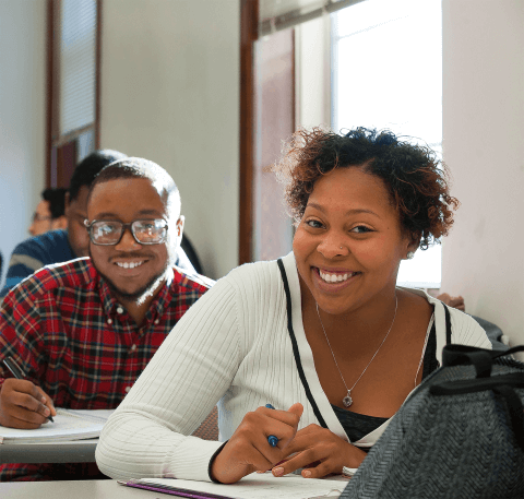 Smiling students in a classroom.