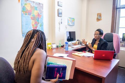 A student in a guidance counselor's office having a discussion with the counselor.