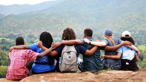 A group of Howard University students linking arms in view of a scenic mountain.