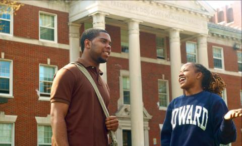 Students engaging in conversation outside of a Howard University building.