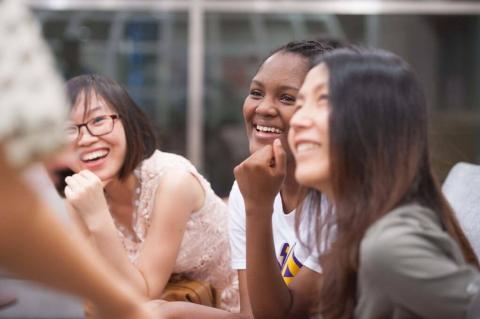 A group of smiling students in a classroom setting.